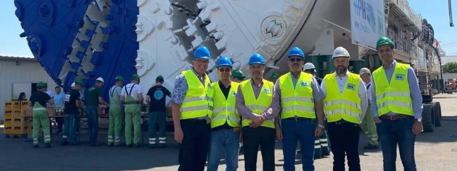 AL-WASET team with partner engineers in front of tunnel-boring equipment at an industrial site